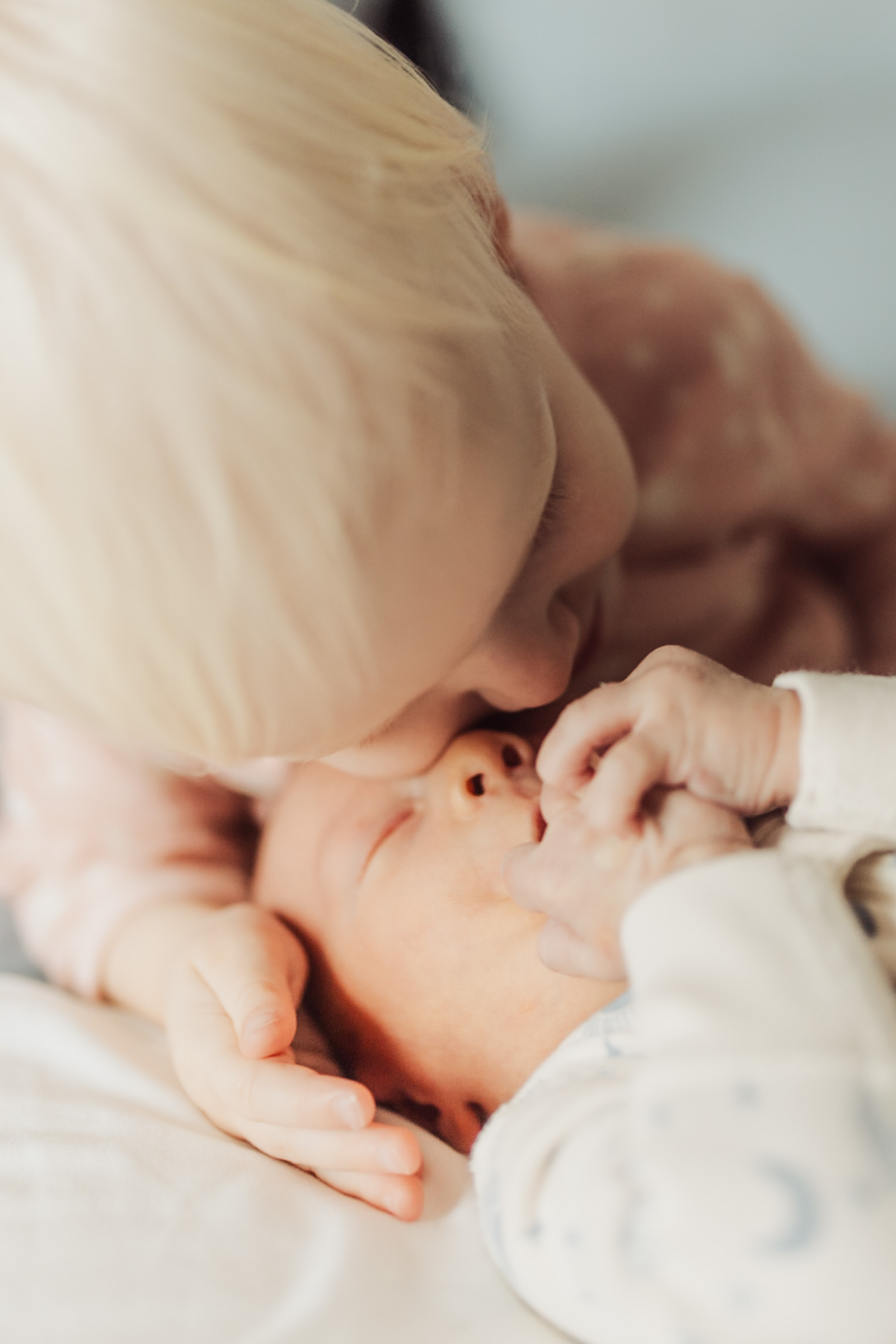 Close newborn detail photograph of a baby resting against a parent