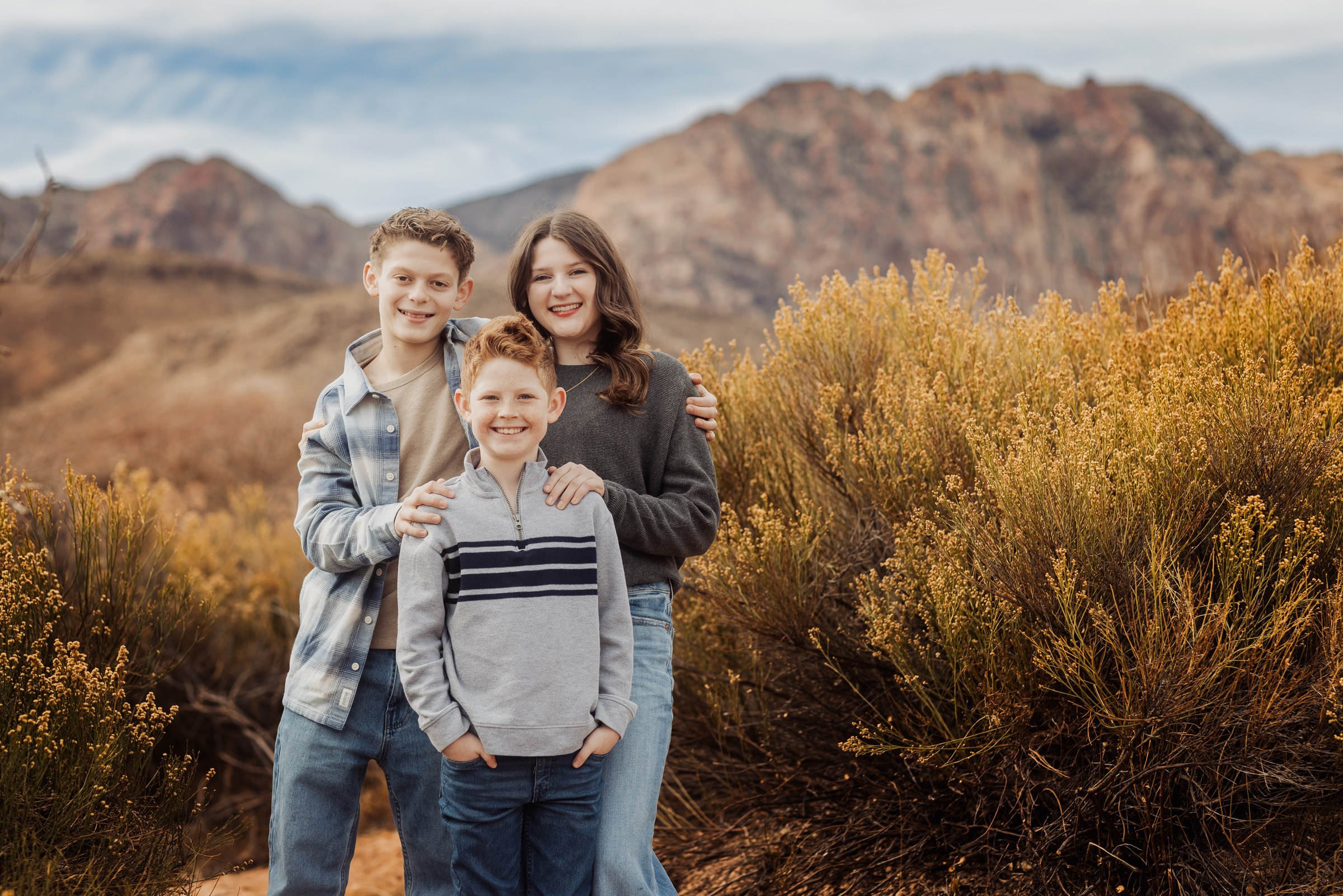 Family photographed in front of the red sandstone escarpment at Red Rock Canyon near Las Vegas