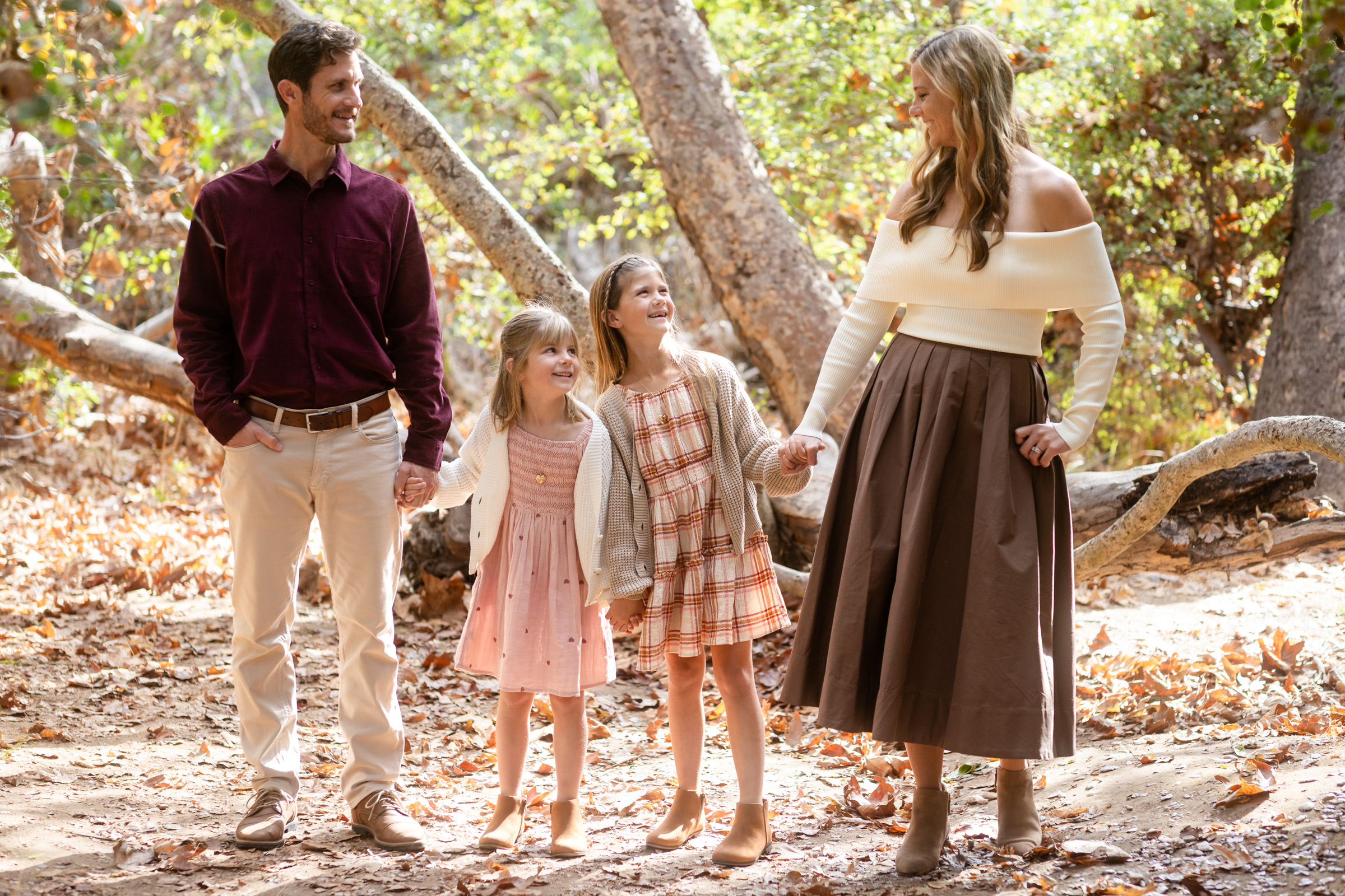 Parents with their two daughters walking together along the shaded oak trail in Los Penasquitos Canyon, San Diego