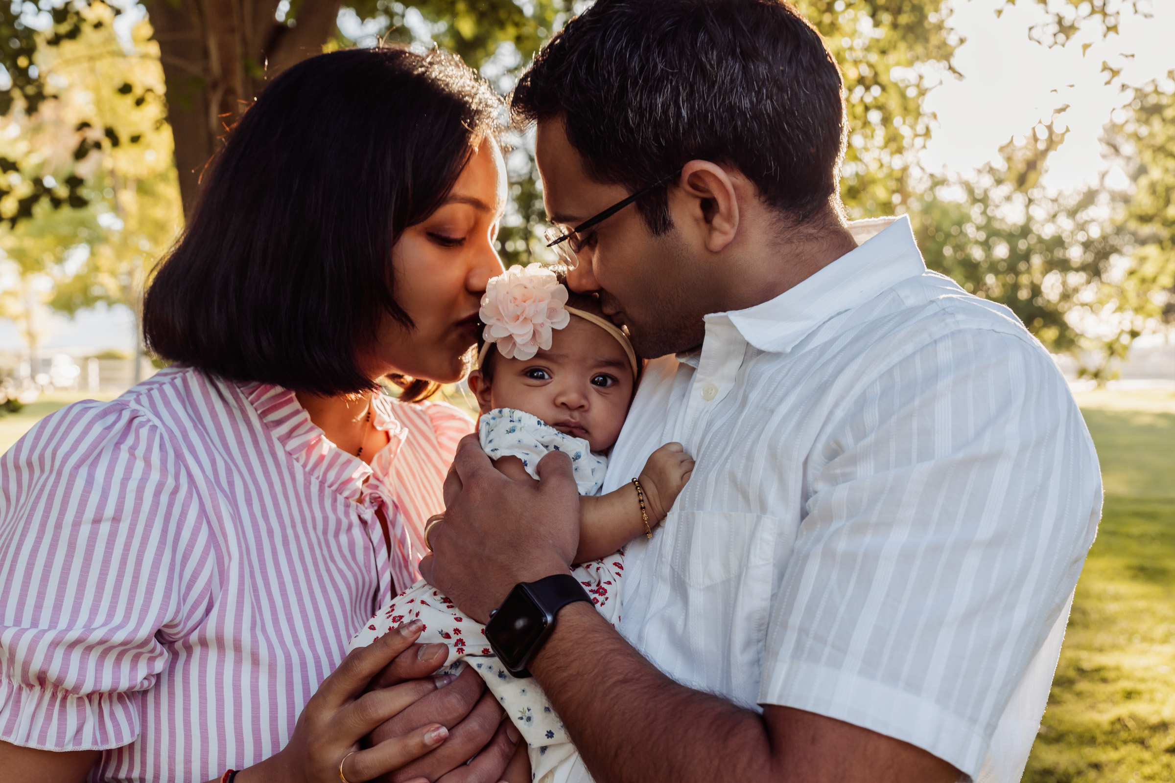 Parents holding their newborn under autumn trees in Centennial Hills, Las Vegas