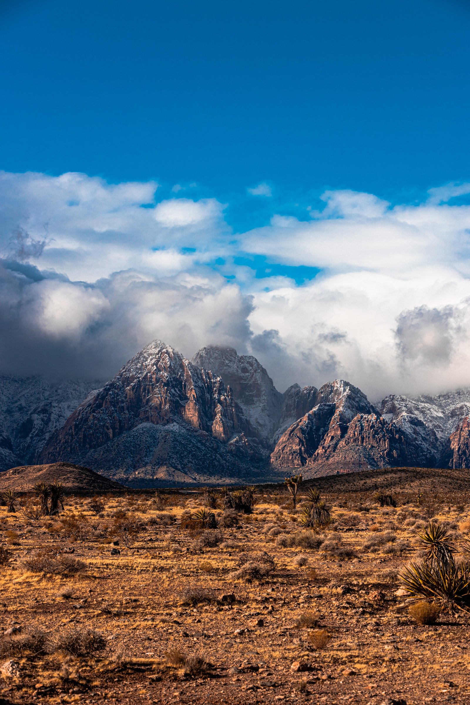 Snow-dusted sandstone mountains beneath heavy clouds at Red Rock Canyon outside Las Vegas