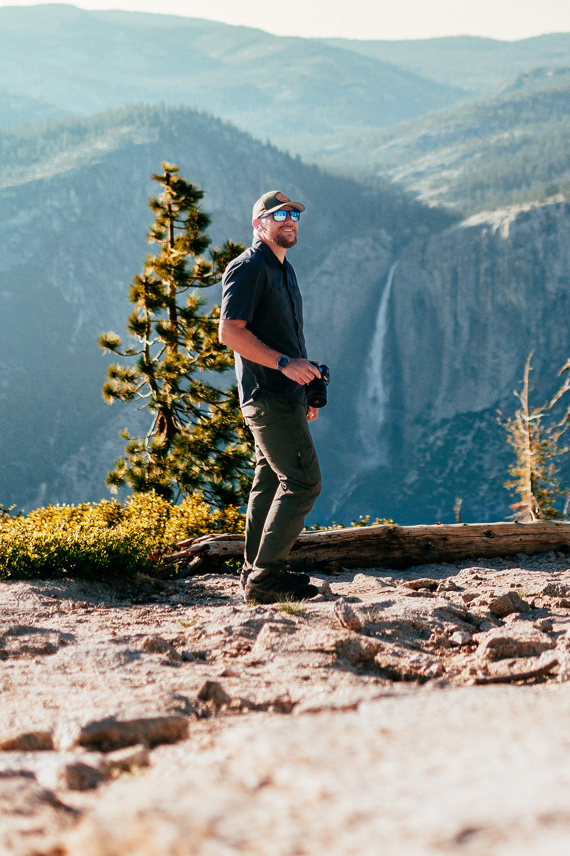Joseph with a camera on a granite overlook above a waterfall