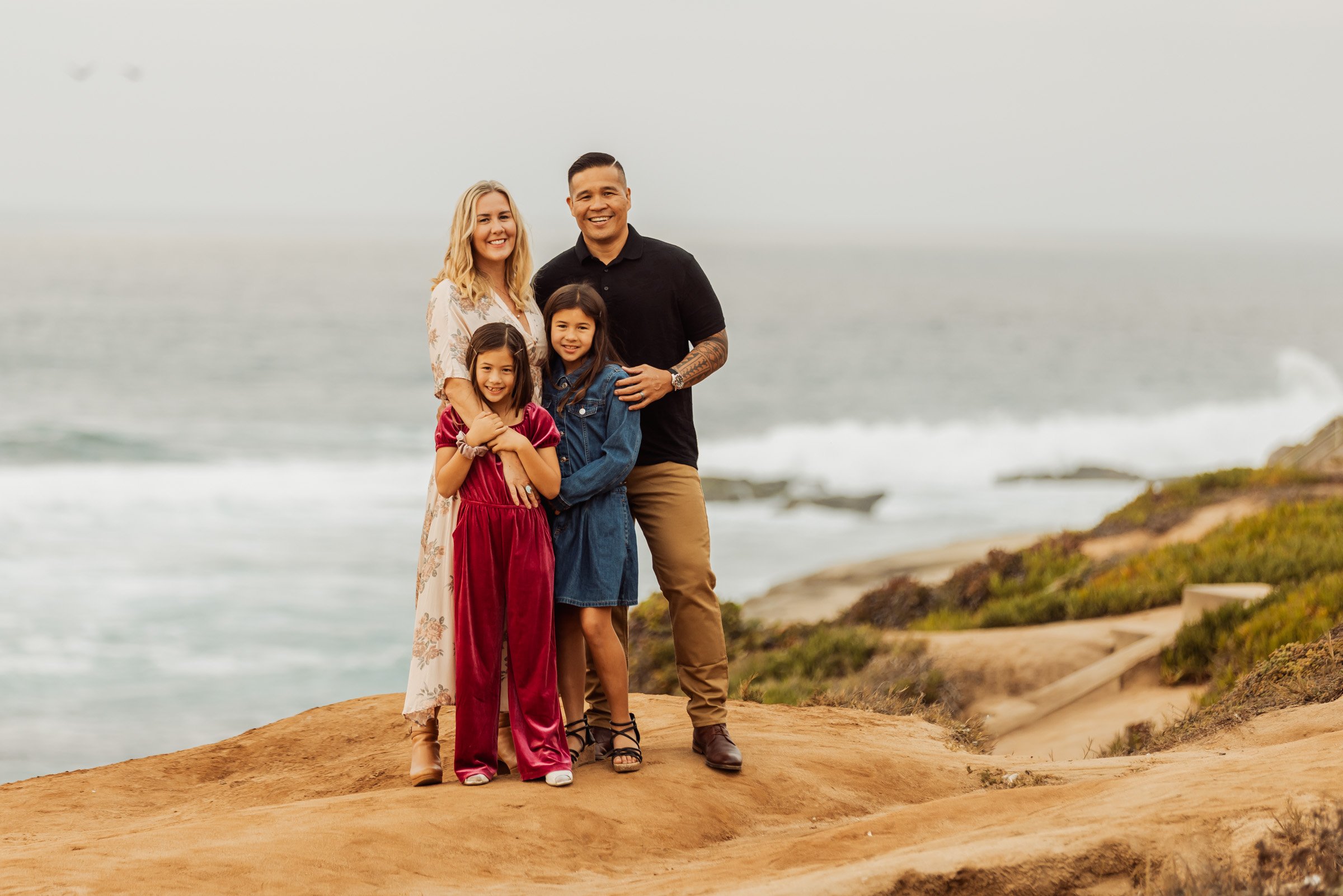 Family standing on the bluff above the water at La Jolla Cove, San Diego