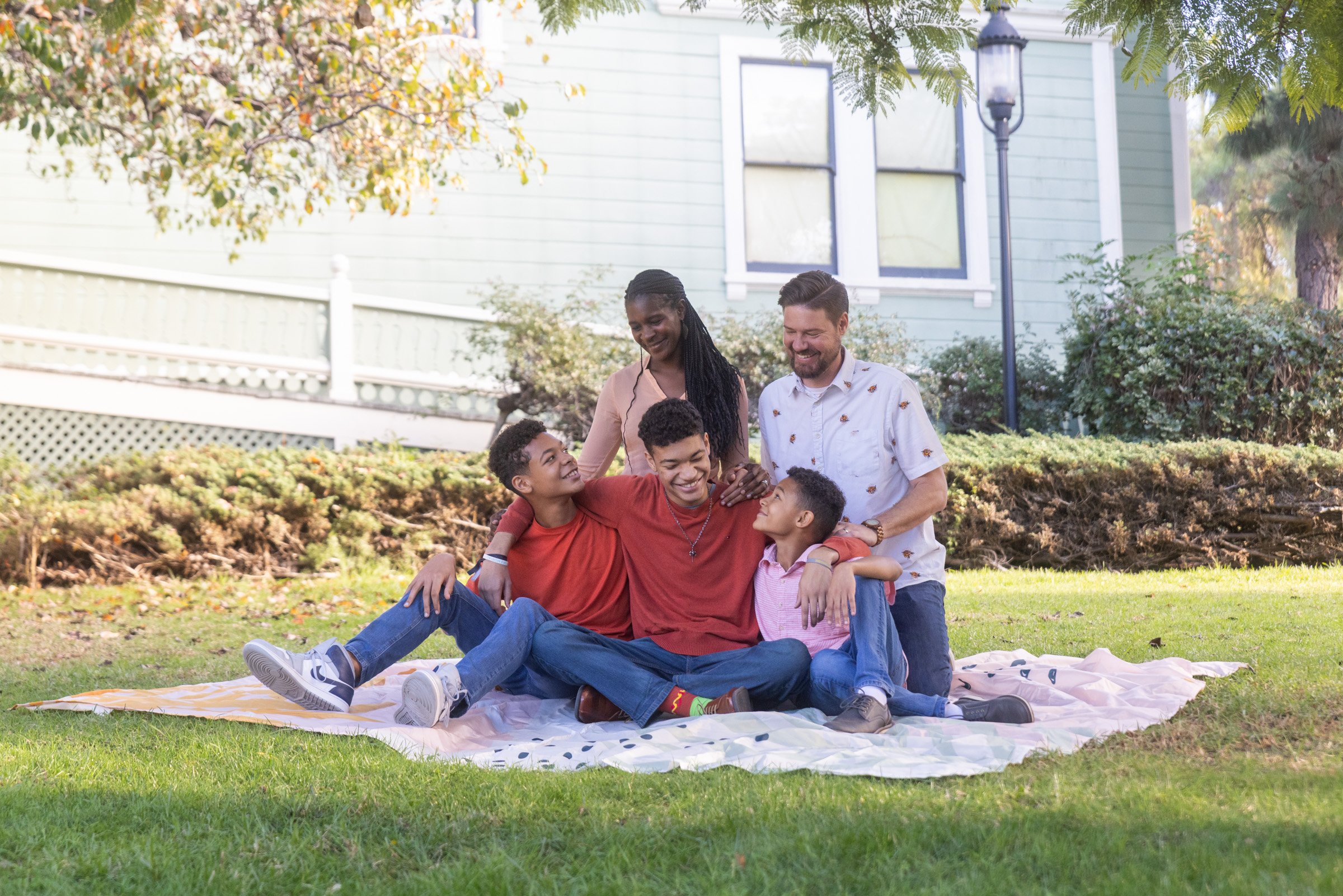Family on a picnic blanket in front of a historic Victorian house in Old Town San Diego