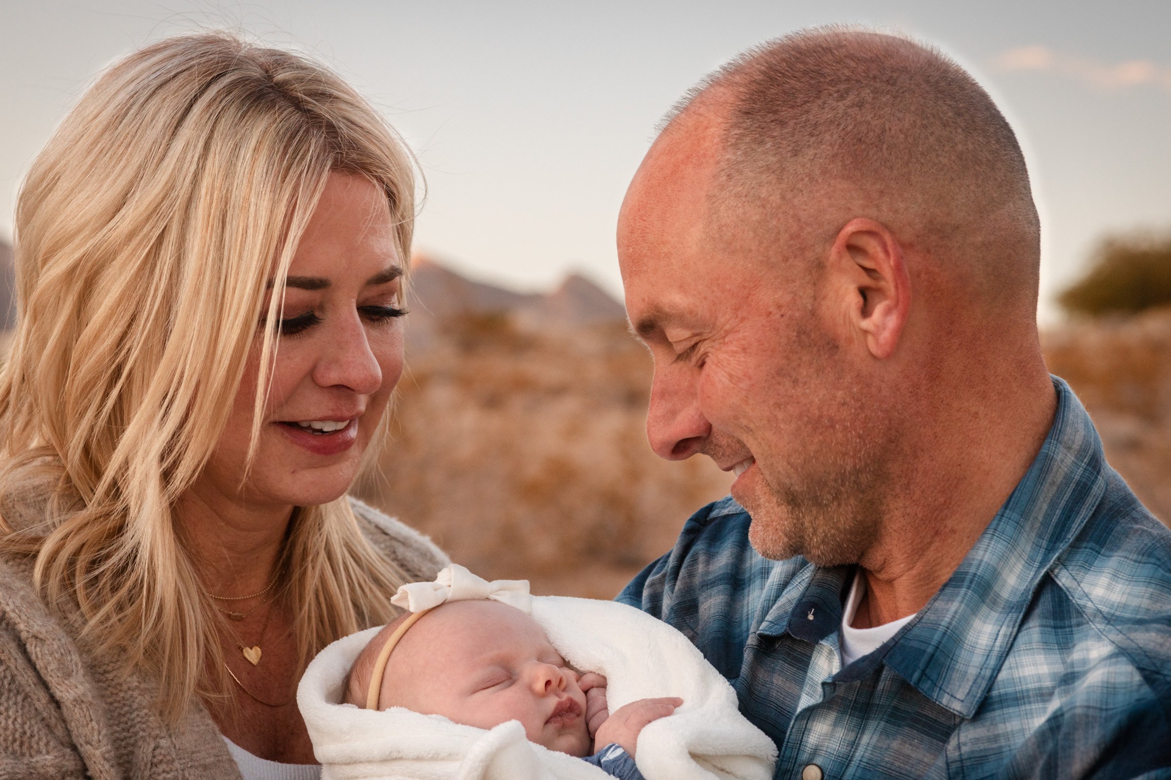 New parents holding their newborn outdoors in Summerlin, Las Vegas