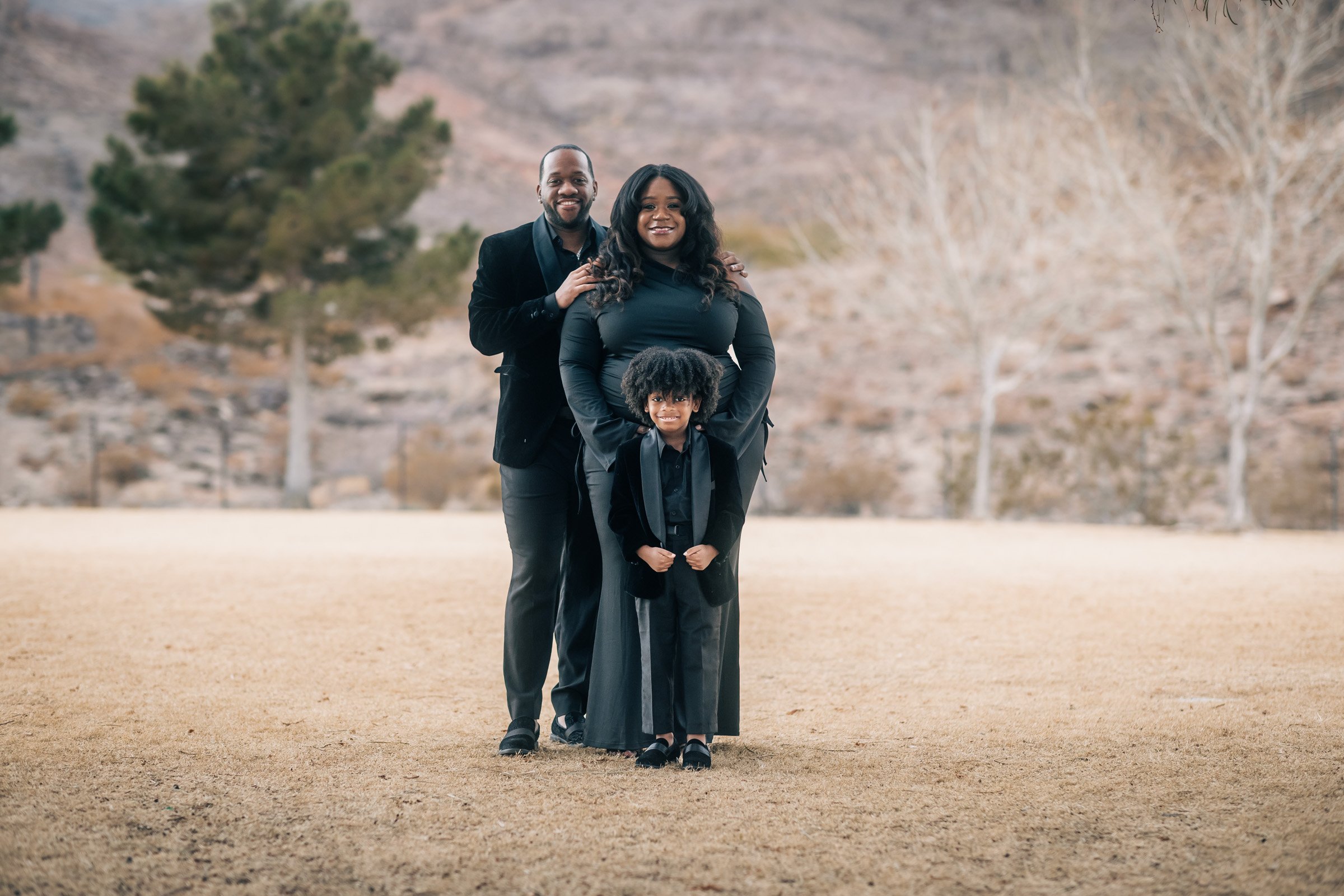Family dressed in black photographed on a Henderson park lawn with the foothills behind them