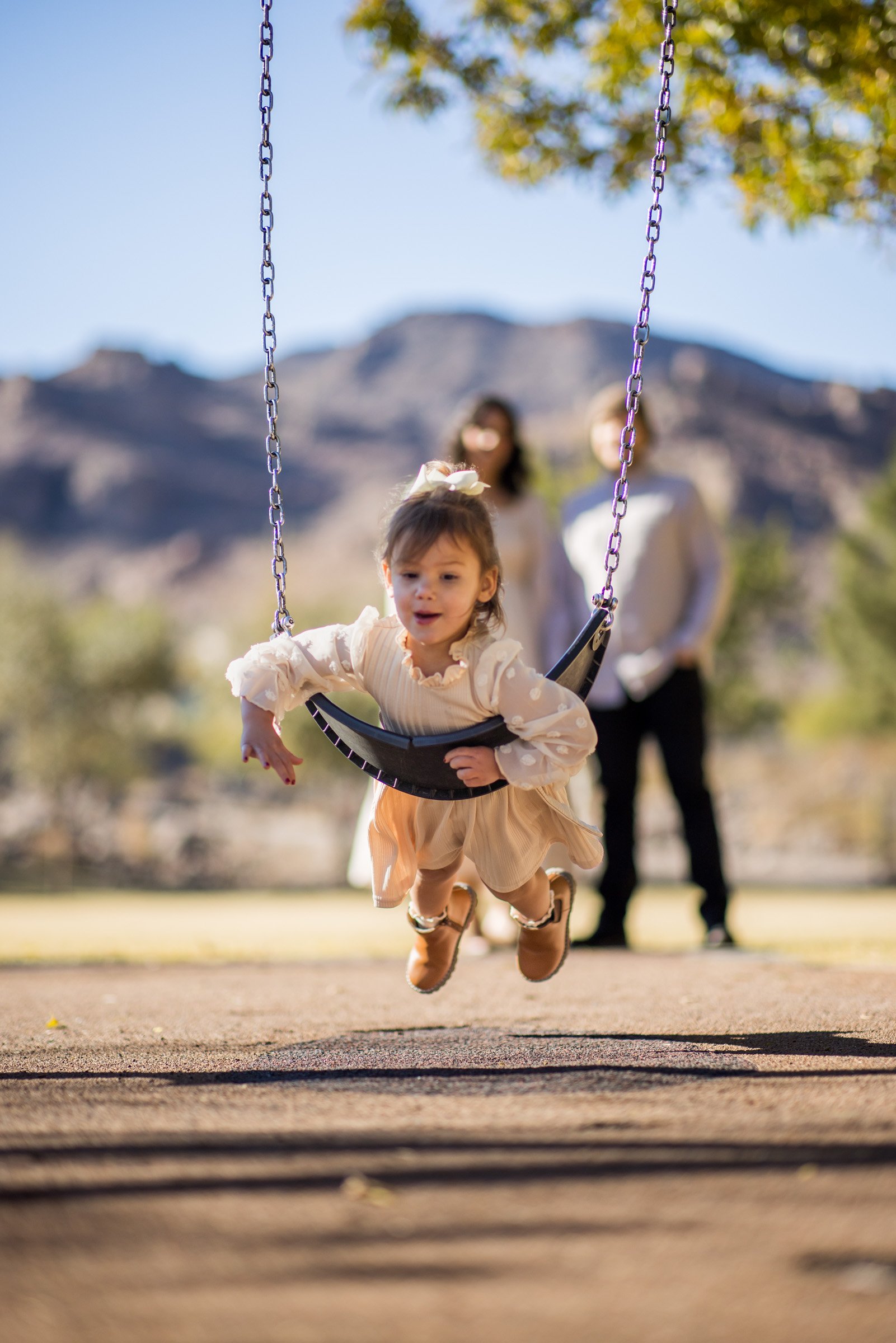 Young girl on a park swing during a Henderson family photo session