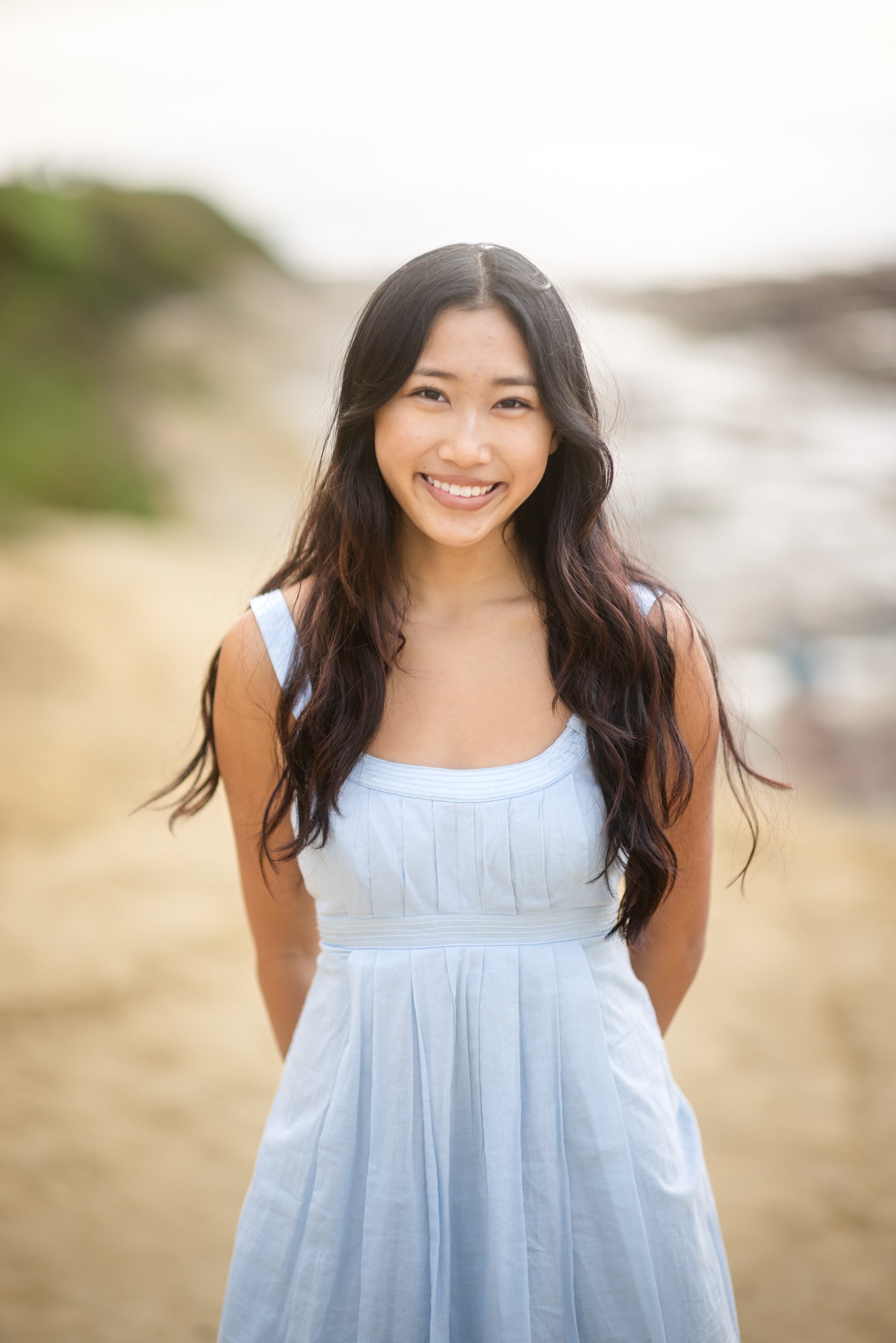 Portrait of a young woman in a white dress at La Jolla Cove, San Diego
